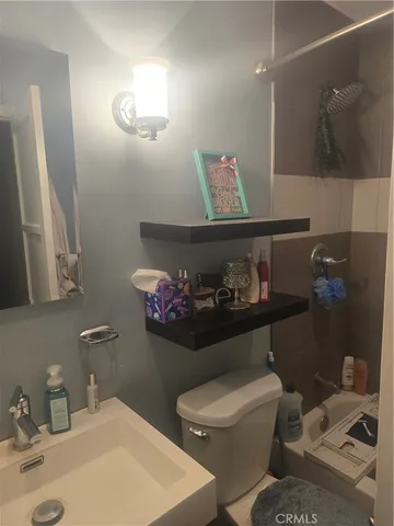 a bathroom with a sink mirror and toilet