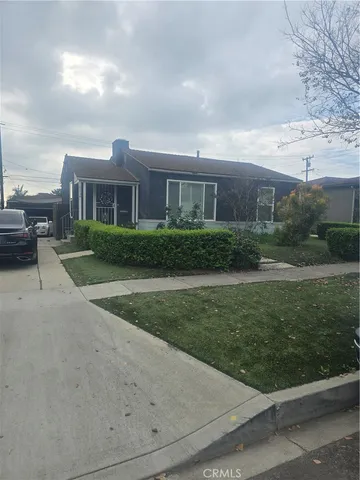 a front view of a house with a garden and yard