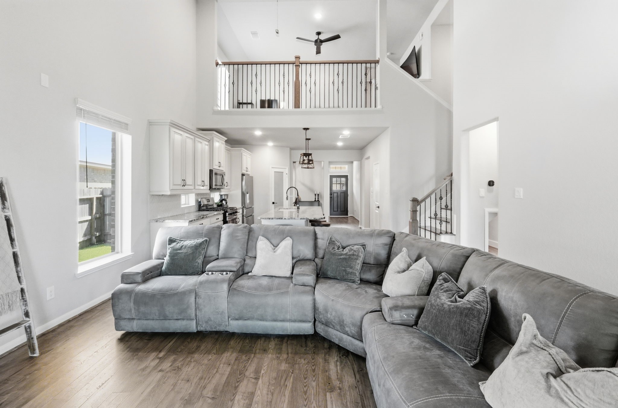 4334 Umber Shadow Drive Spring, TX 77386 - Photo 14 of 45 Family room features soaring two-story ceilings, expansive windows, and an open-concept design that connects seamlessly to the upper level and adjacent living spaces.