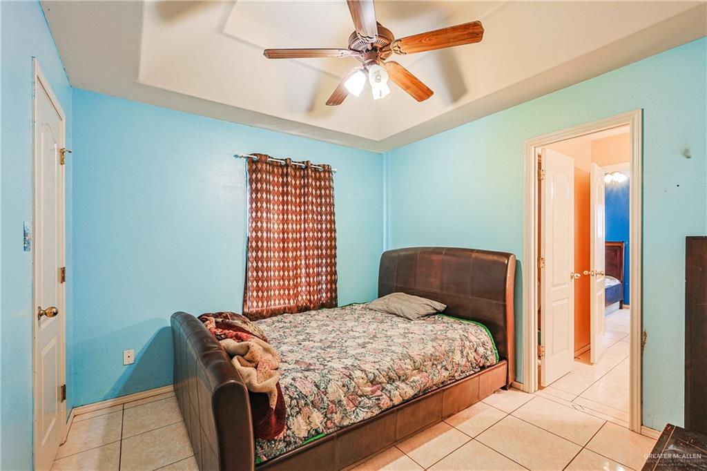 713 West 24th Place Mission, TX 78574 - Photo 23 of 36 a bedroom with a bed and a chandelier