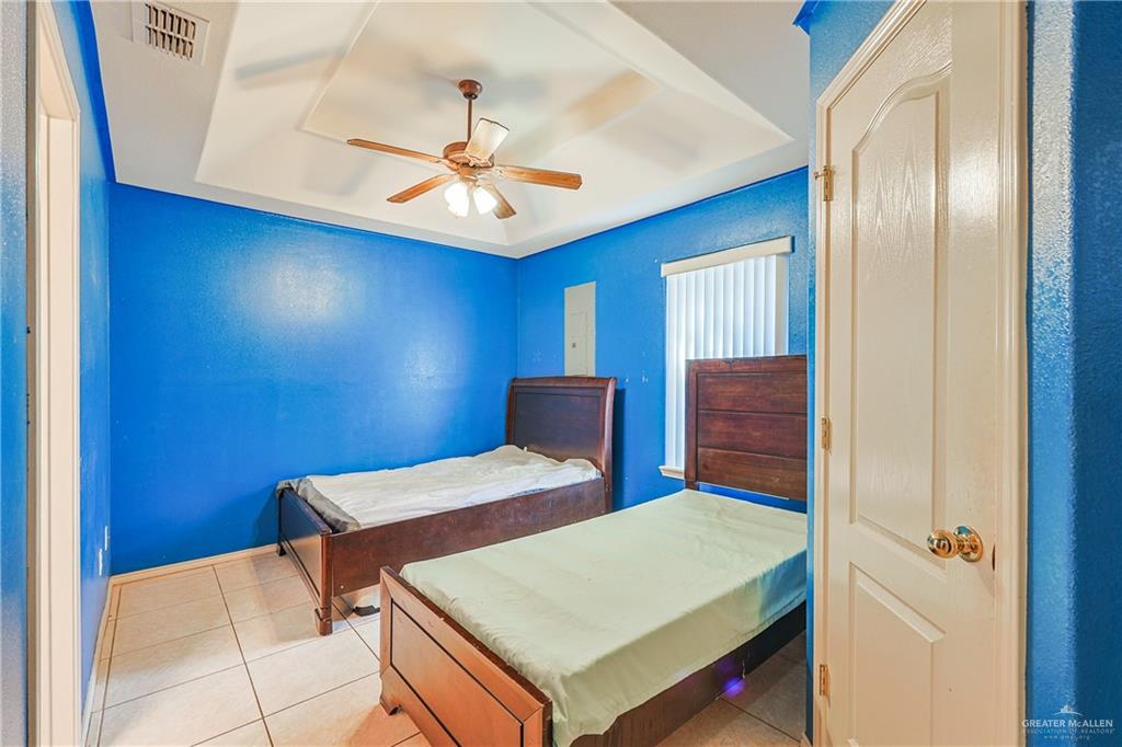 713 West 24th Place Mission, TX 78574 - Photo 28 of 36 a bedroom with a bed and a chandelier