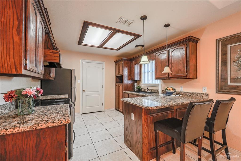 713 West 24th Place Mission, TX 78574 - Photo 9 of 36 a kitchen with stainless steel appliances granite countertop a sink stove and cabinets