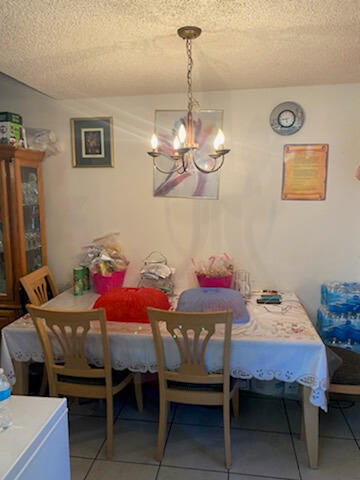 3253 Kirk Road, Unit 8 Lake Worth, FL 33461 - Photo 5 of 8 a view of a dining room with furniture and chandelier