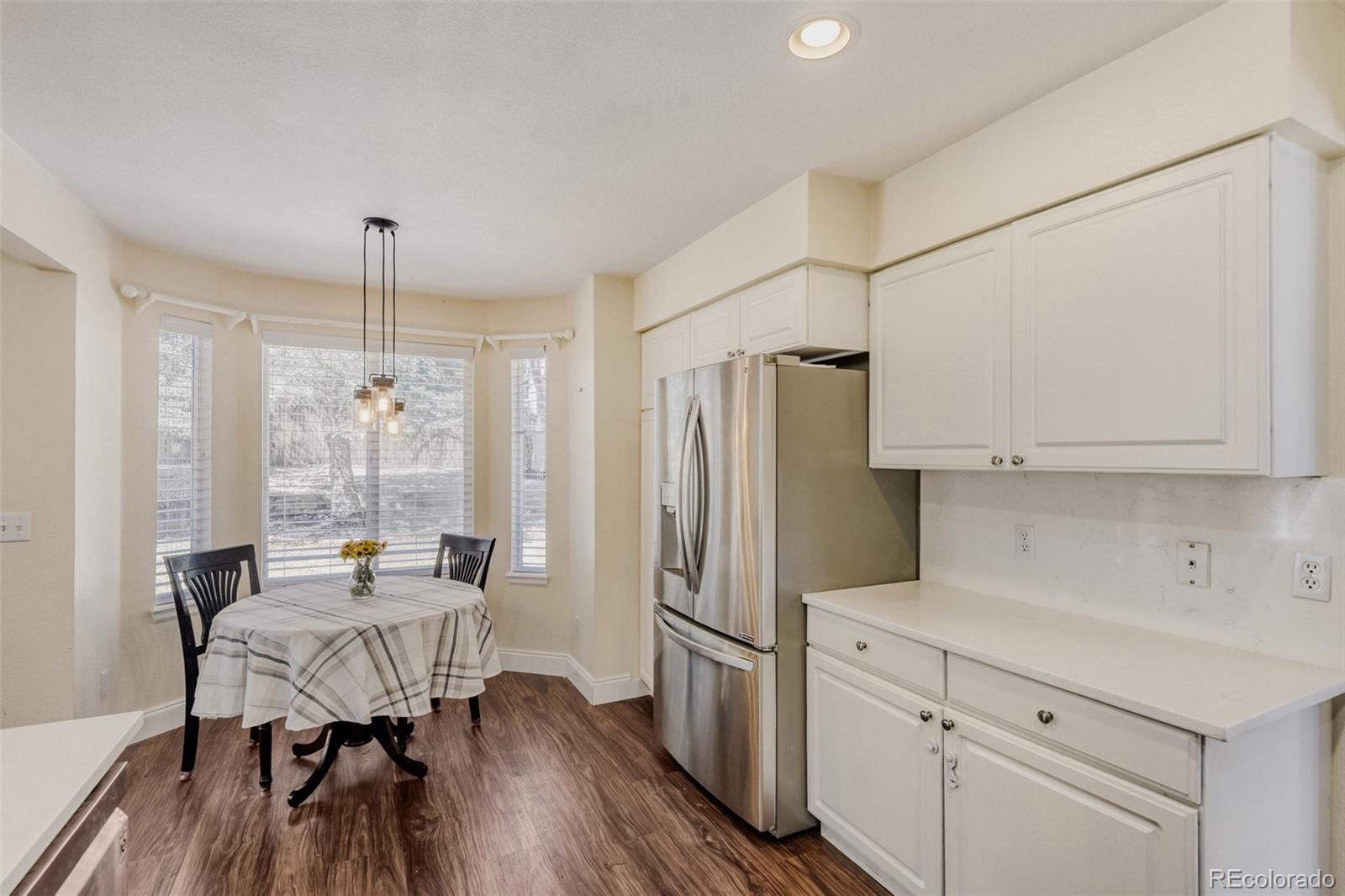 10047 Andrush Court Lone Tree, CO 80124 - Photo 14 of 37 a kitchen with stainless steel appliances a dining table chairs a refrigerator and chandelier