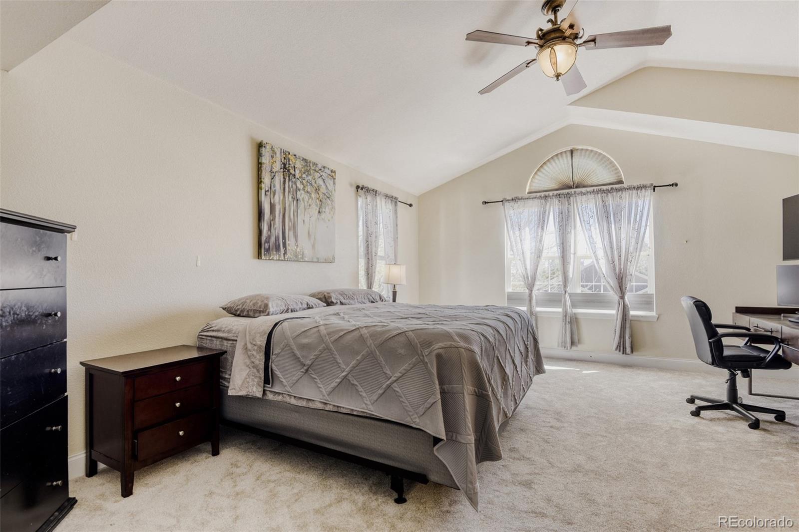 10047 Andrush Court Lone Tree, CO 80124 - Photo 22 of 37 a bedroom with a bed and a chandelier