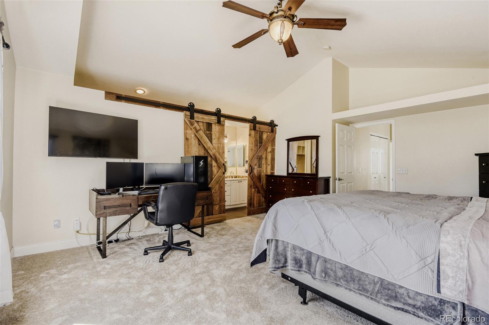 10047 Andrush Court Lone Tree, CO 80124 - Photo 23 of 37 a bedroom with a bed a chair and the flat screen tv