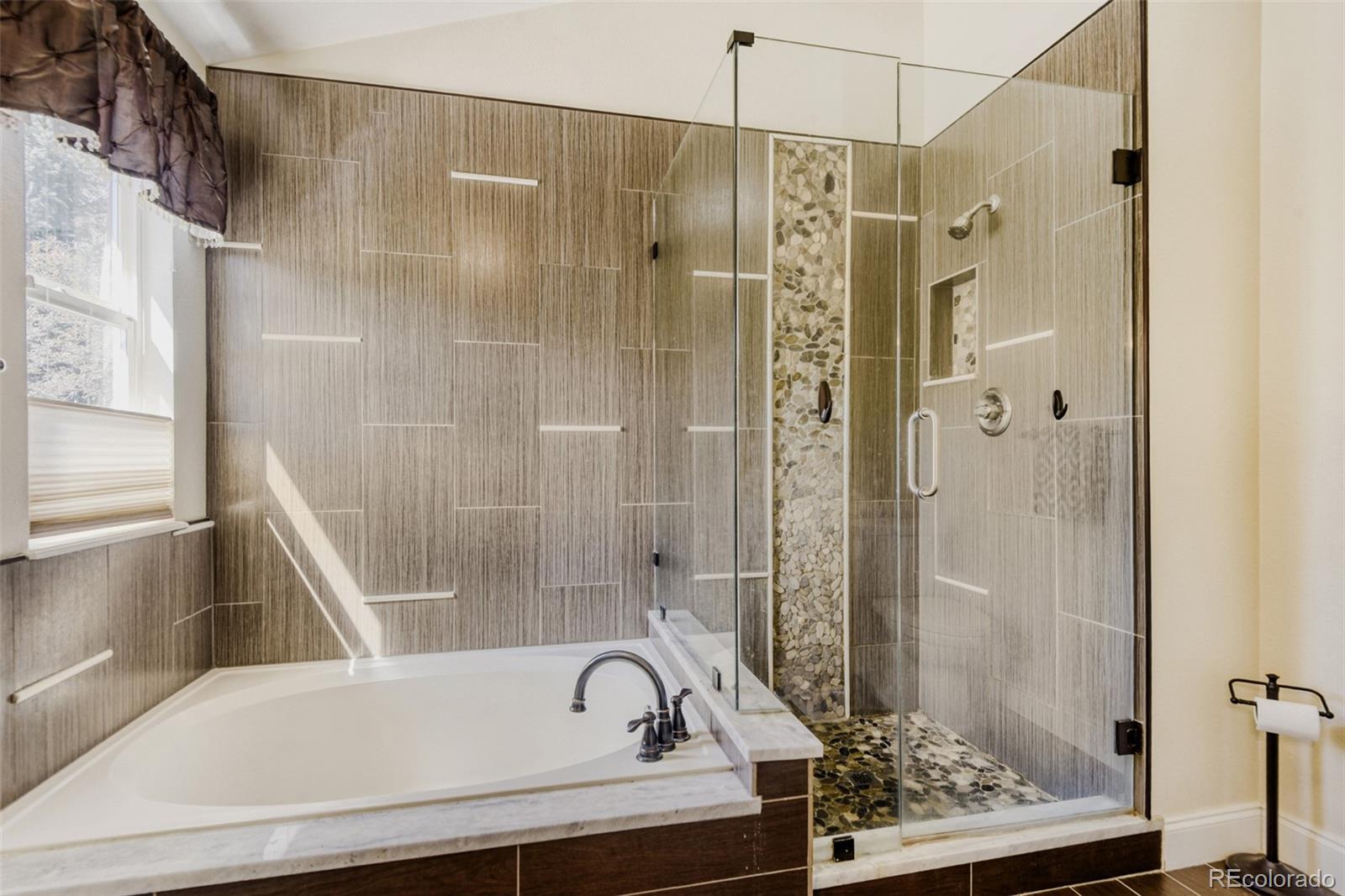 10047 Andrush Court Lone Tree, CO 80124 - Photo 25 of 37 a bathroom with a bathtub and a shower