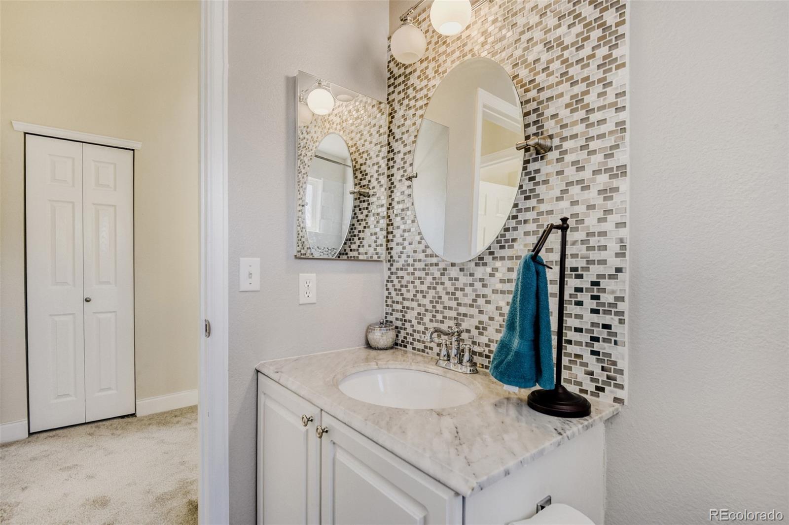 10047 Andrush Court Lone Tree, CO 80124 - Photo 31 of 37 a bathroom with a granite countertop sink a mirror and shower
