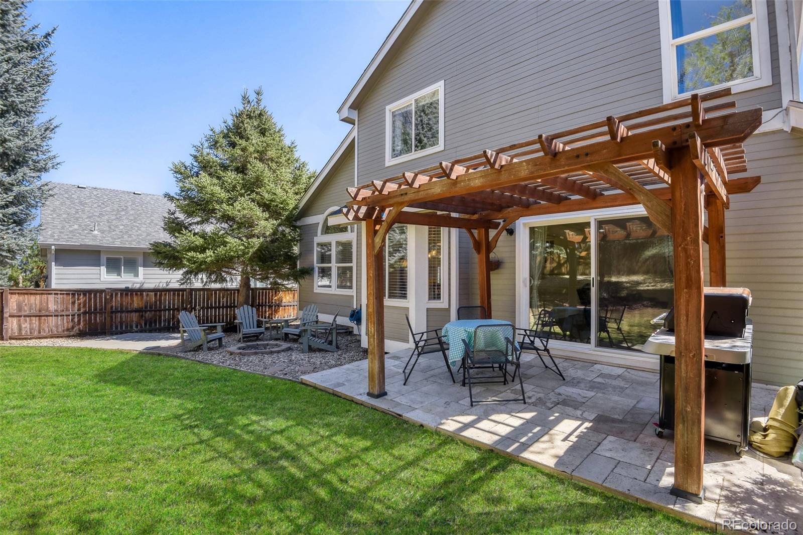10047 Andrush Court Lone Tree, CO 80124 - Photo 32 of 37 a view of a patio with table and chairs under an umbrella