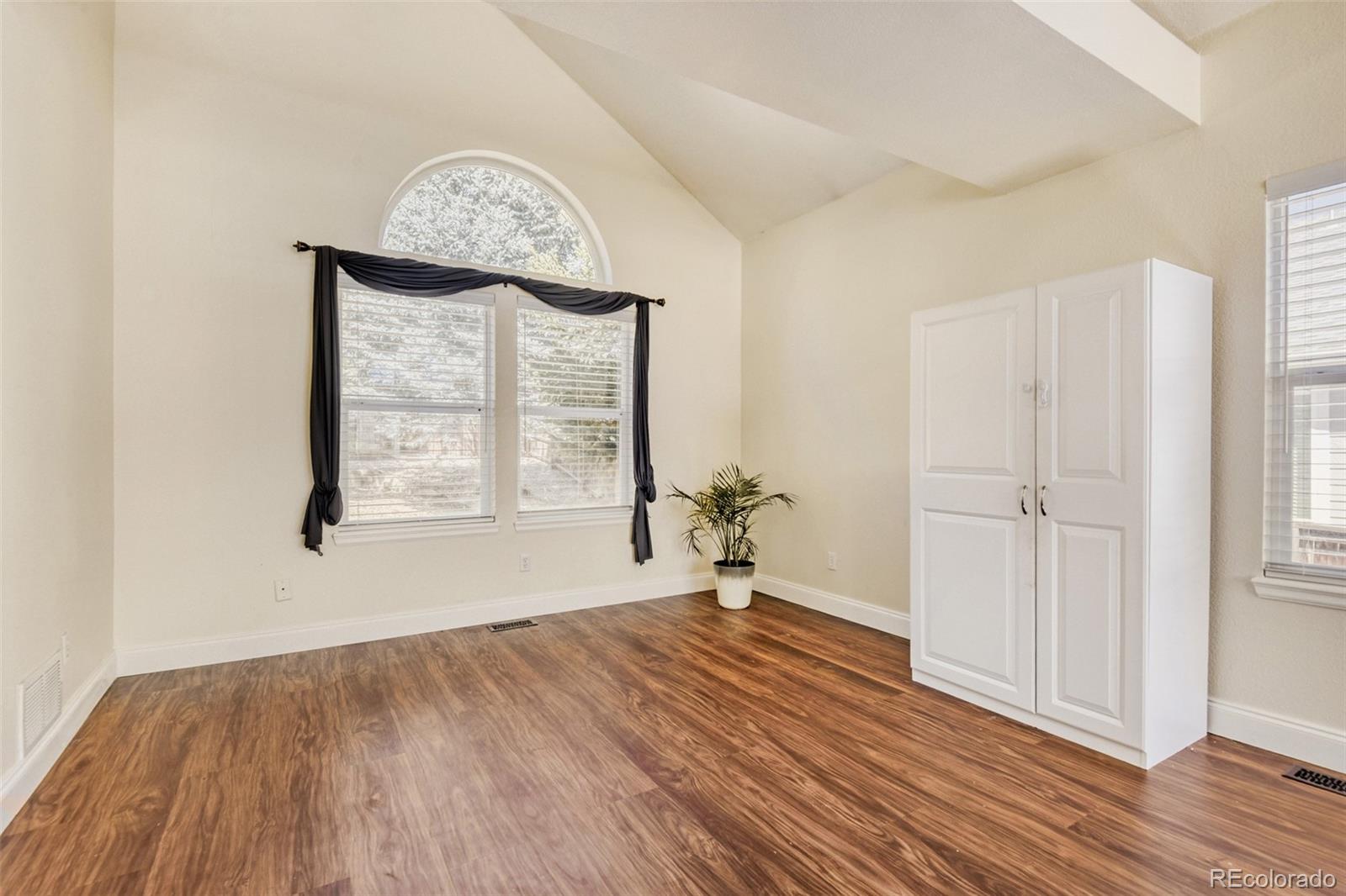 10047 Andrush Court Lone Tree, CO 80124 - Photo 9 of 37 an empty room with wooden floor cabinet and windows