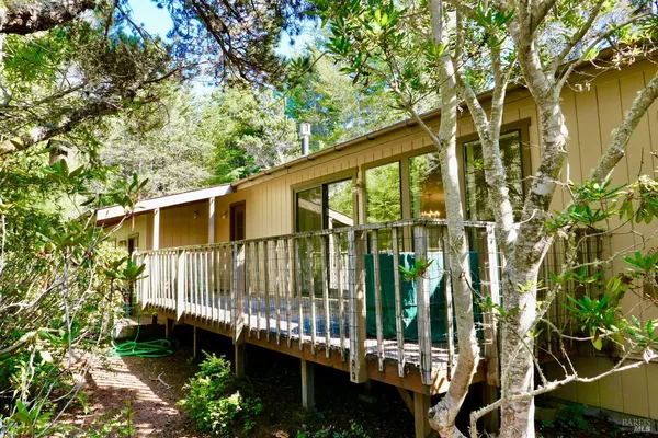 a view of a house with a small yard and wooden fence