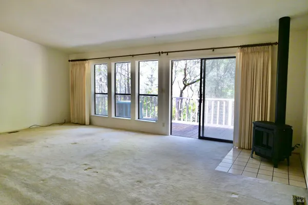 a view of an empty room with a fireplace and a window