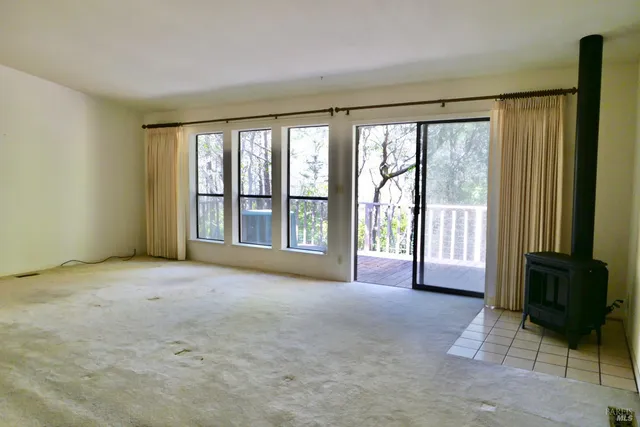a view of an empty room with a fireplace and a window