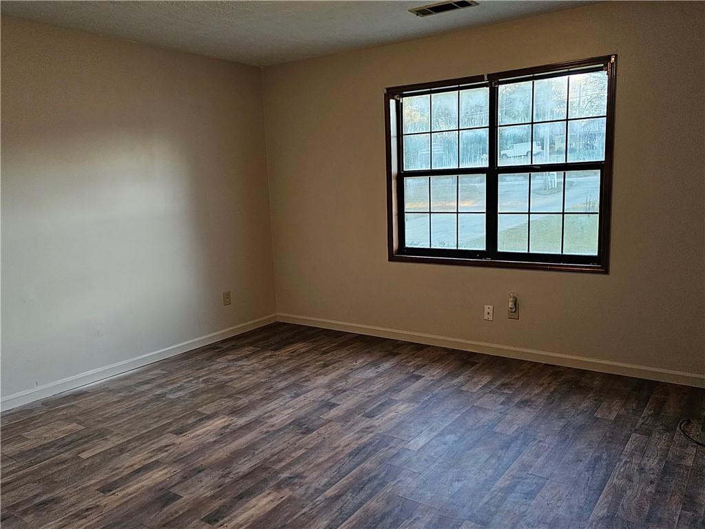 2835 Springdale Road, Unit B Snellville, GA 30039 - Photo 13 of 21 a view of an empty room with wooden floor and a window