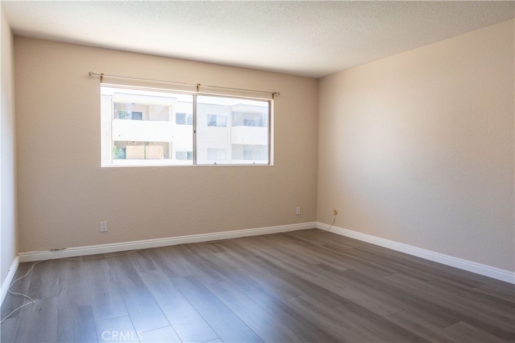 2386 East Del Mar Boulevard, Unit 203 Pasadena, CA 91107 - Photo 11 of 28 an empty room with wooden floor and windows