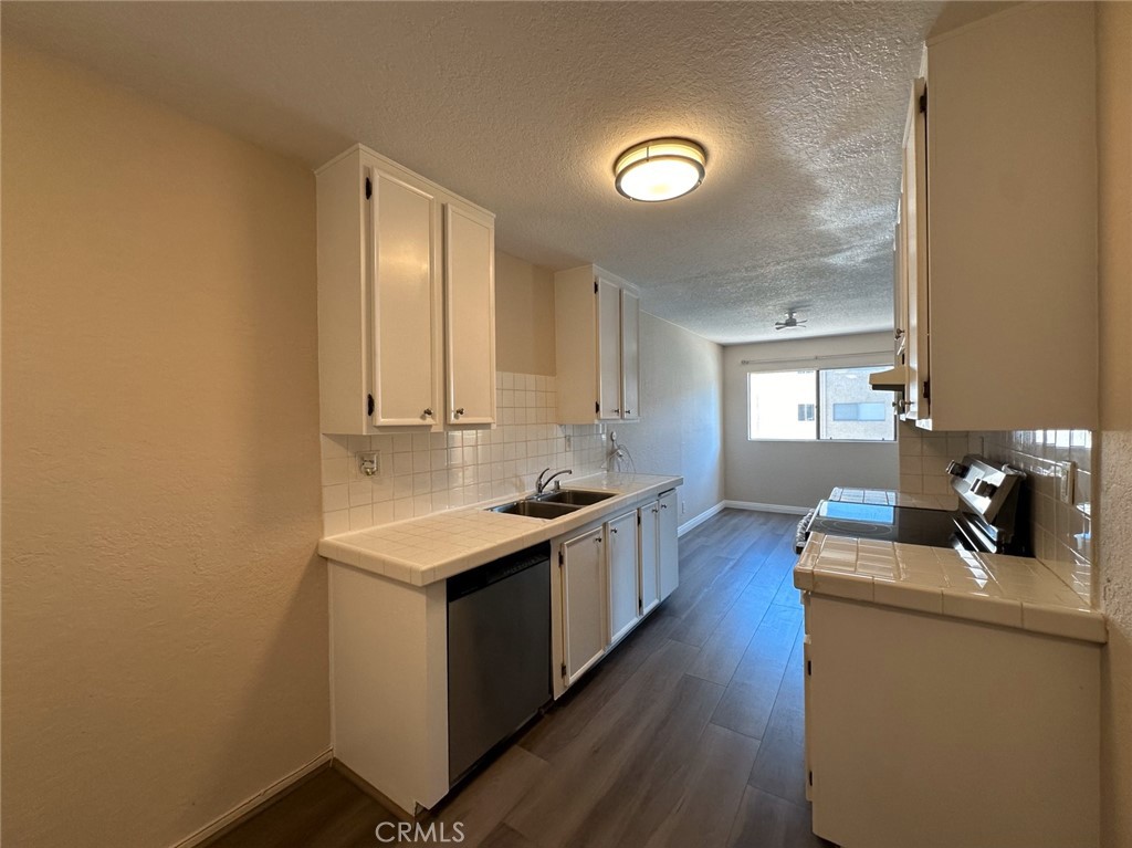 2386 East Del Mar Boulevard, Unit 203 Pasadena, CA 91107 - Photo 16 of 28 a kitchen with a stove and wooden floor