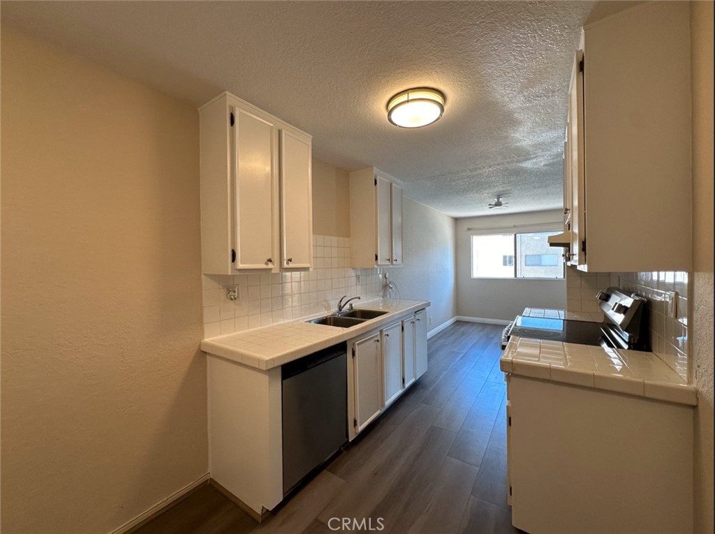 2386 East Del Mar Boulevard, Unit 203 Pasadena, CA 91107 - Photo 27 of 28 a kitchen with a stove and wooden floor