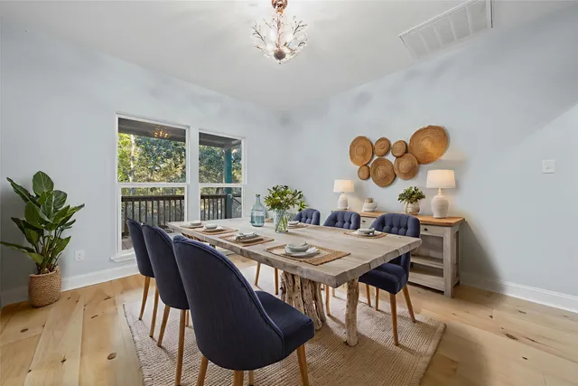 a dining room with furniture potted plants and wooden floor