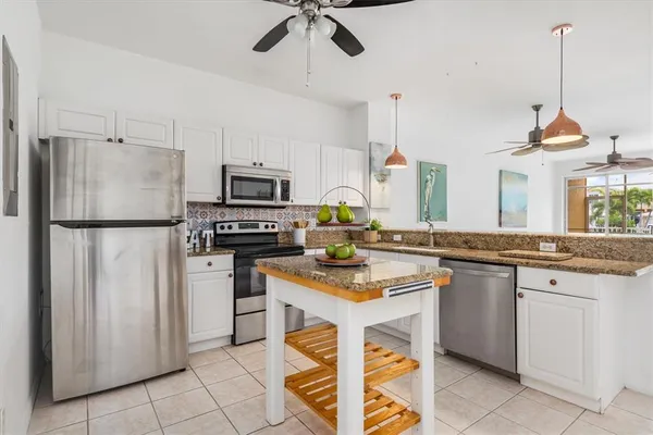 a kitchen with appliances a sink and cabinets