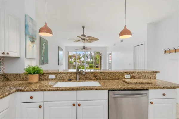 a kitchen with granite countertop a sink and chandelier