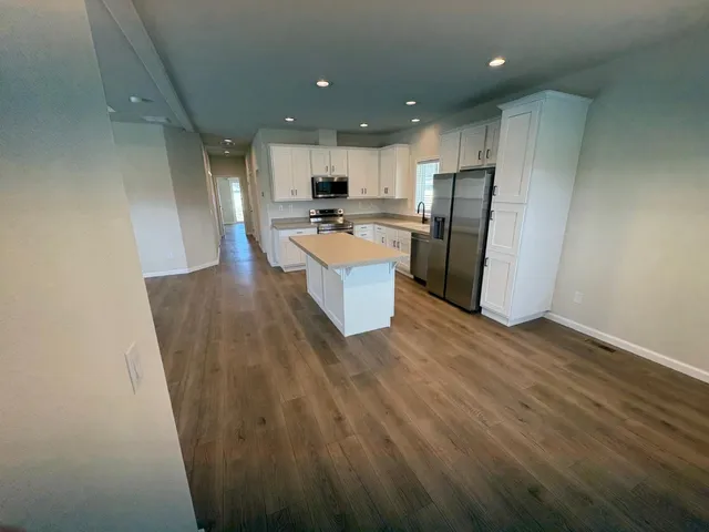 a large kitchen with a refrigerator a counter top space and cabinets