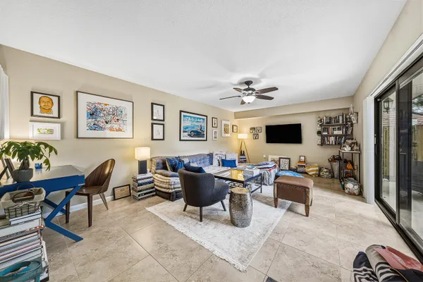 a living room with furniture a flat screen tv and kitchen view