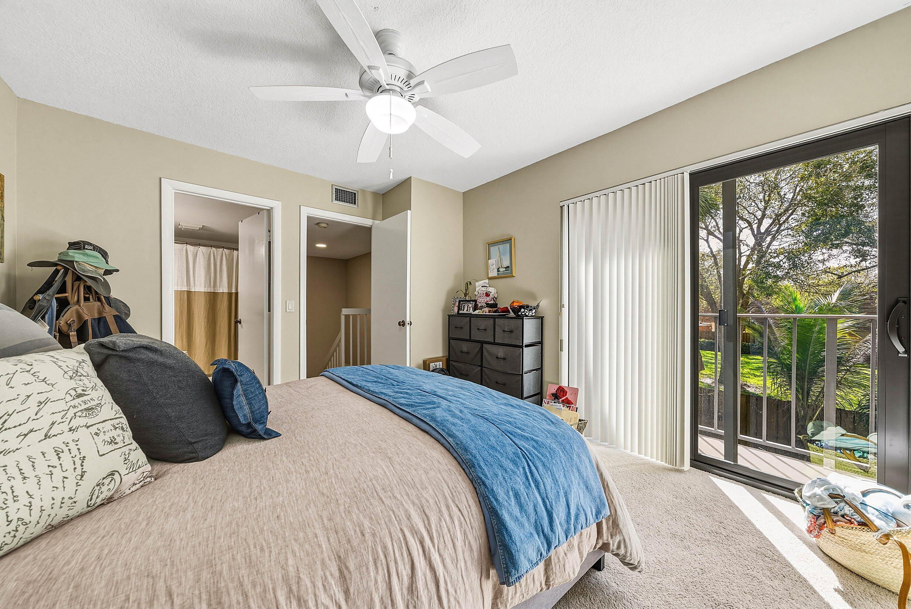 2715 27th Court Jupiter, FL 33477 - Photo 17 of 22 a bedroom with a bed and a large window