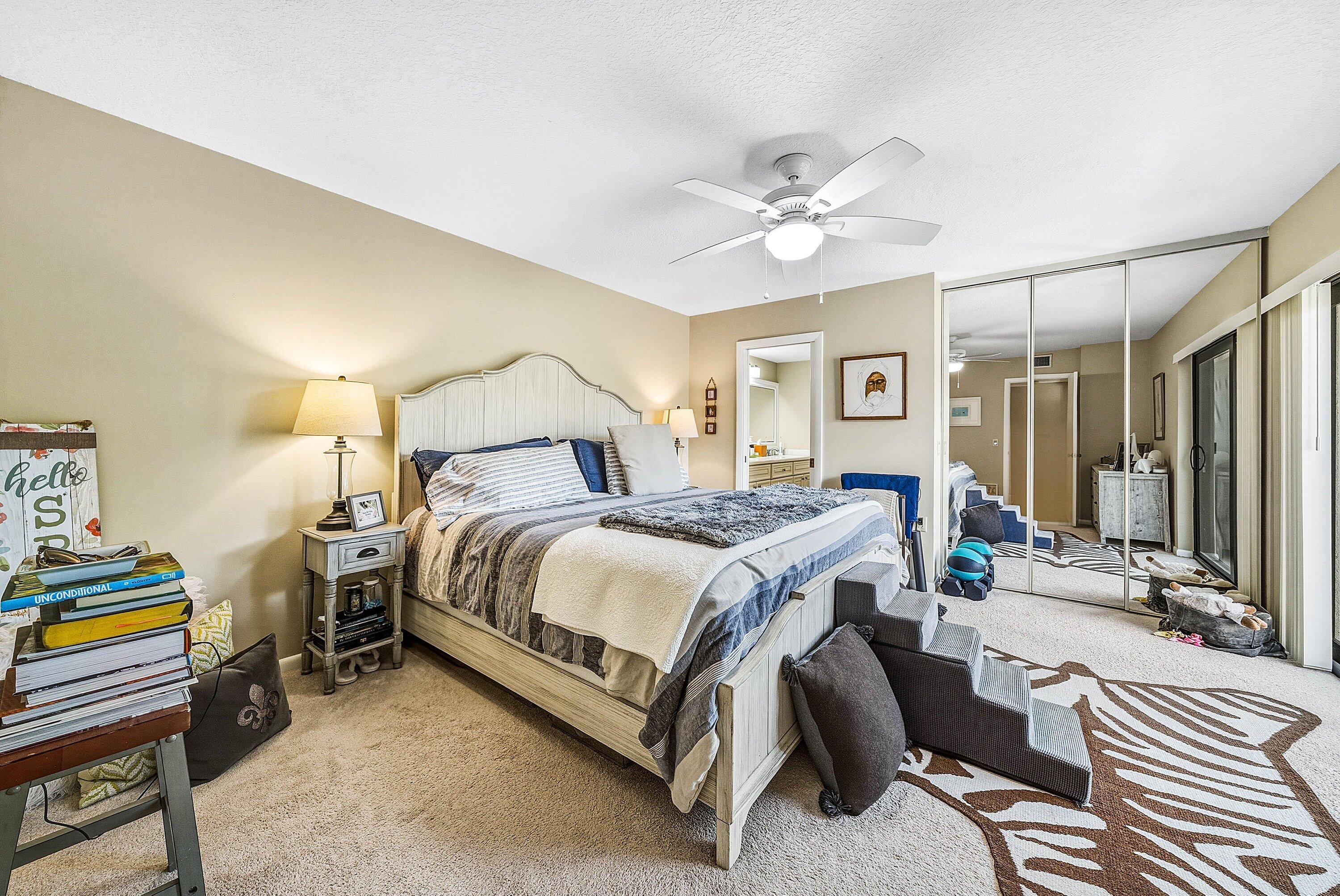 2715 27th Court Jupiter, FL 33477 - Photo 18 of 22 a bedroom with a bed gym equipment and a chandelier