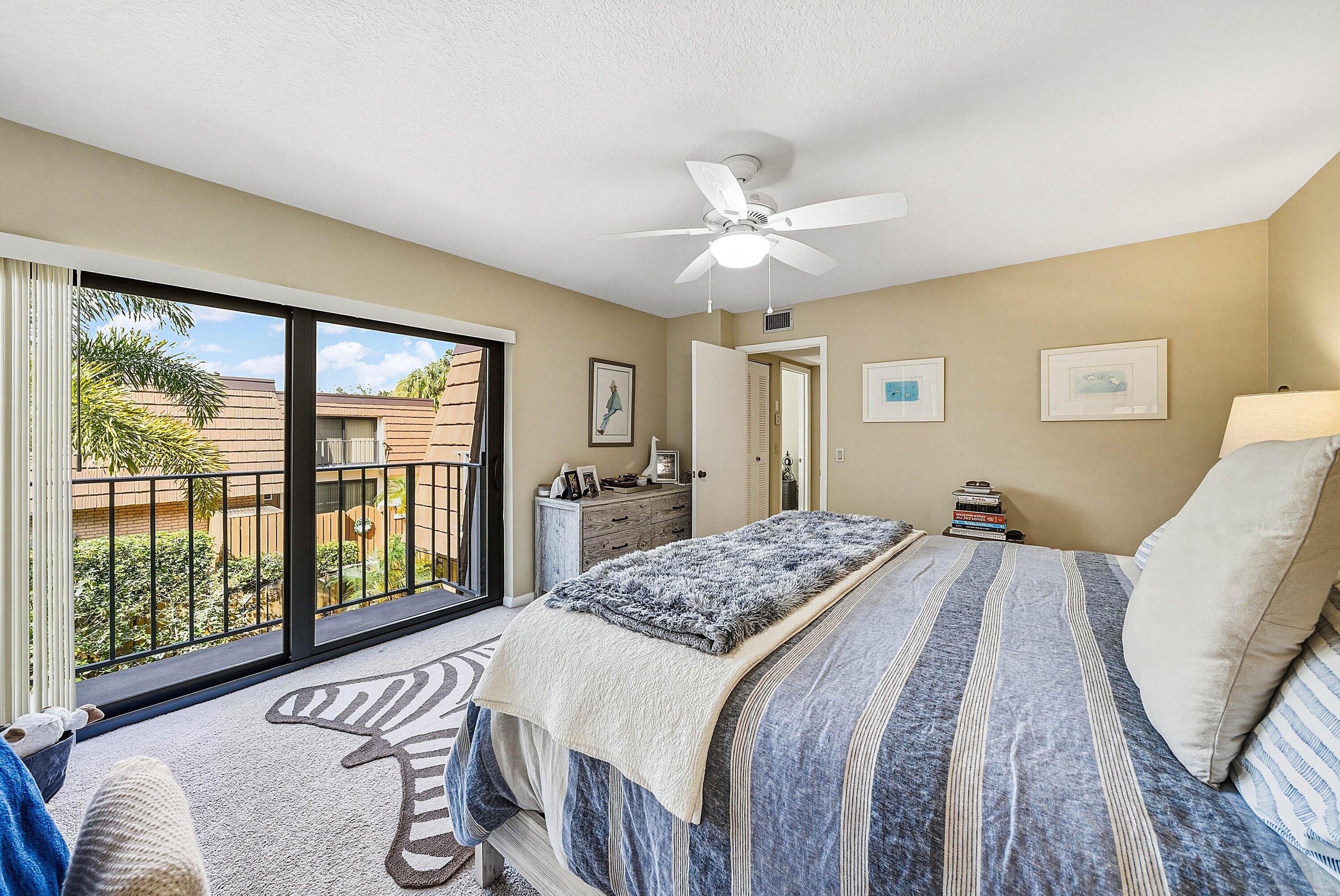 2715 27th Court Jupiter, FL 33477 - Photo 19 of 22 a bedroom with a large bed and a large window