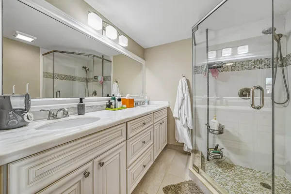 a bathroom with a double vanity sink mirror and shower