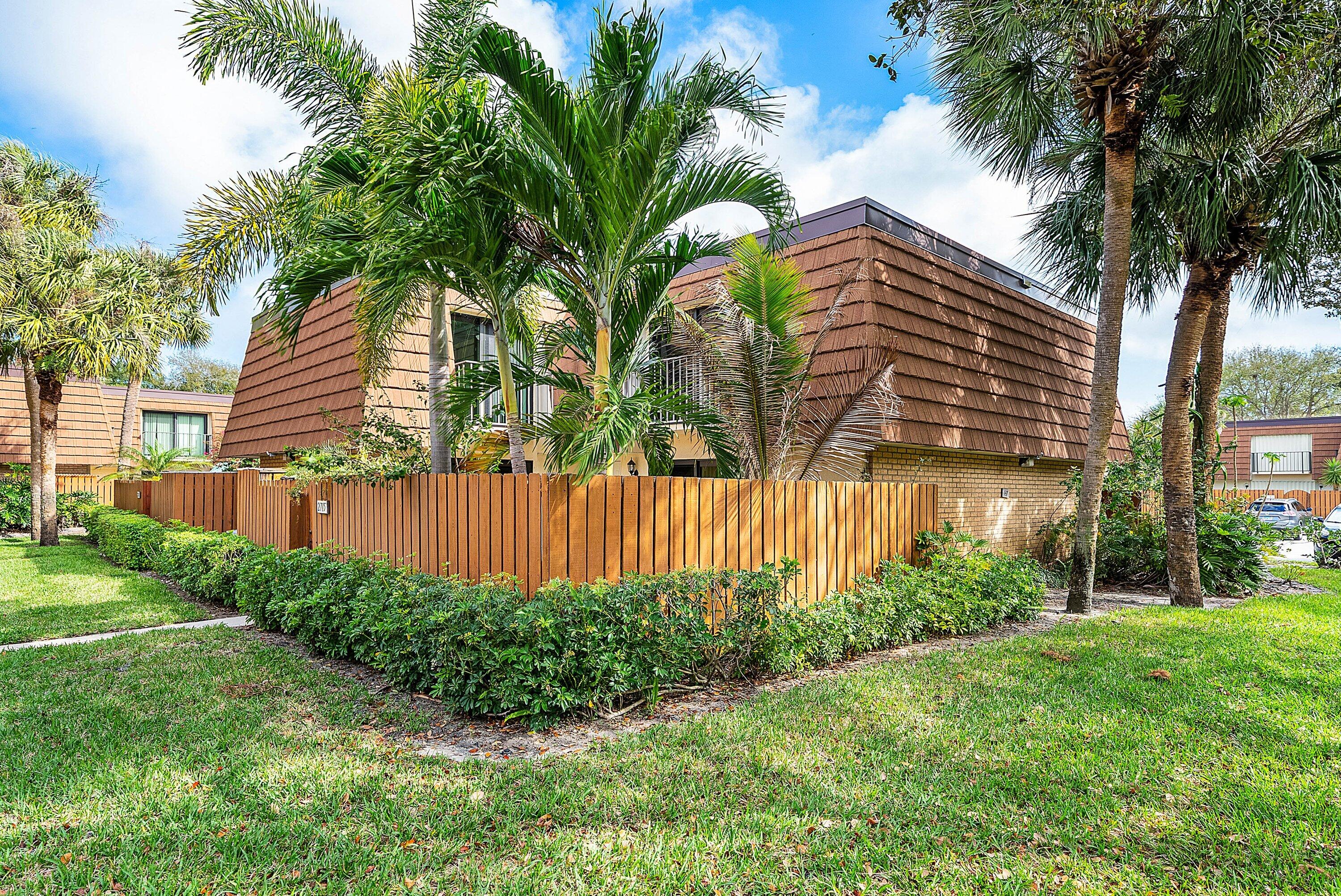 2715 27th Court Jupiter, FL 33477 - Photo 5 of 22 a view of a backyard with potted plants and large trees