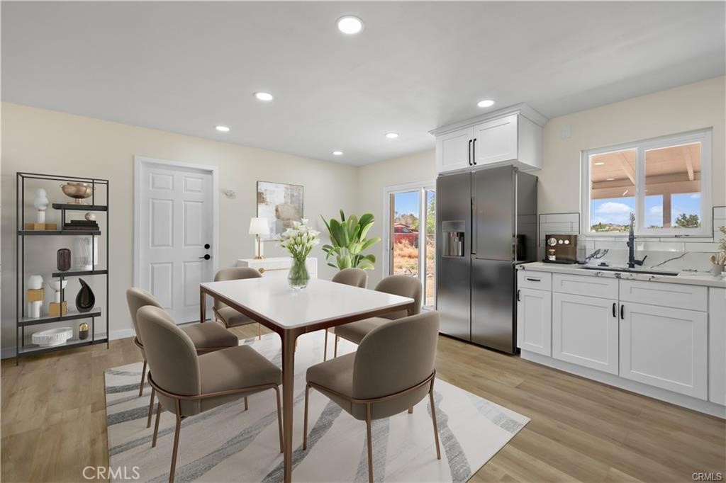 40635 159th Street East Lancaster, CA 93535 - Photo 6 of 25 a kitchen with stainless steel appliances kitchen island granite countertop a refrigerator a stove a sink a dining table and chairs