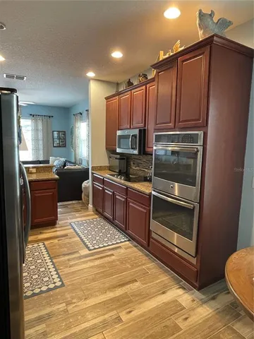 a kitchen with granite countertop a refrigerator stove top oven and sink