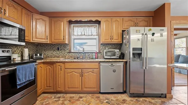 a kitchen with stainless steel appliances granite countertop a refrigerator sink and cabinets