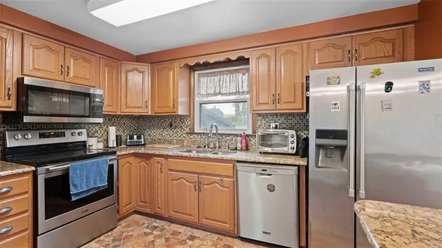 a kitchen with stainless steel appliances granite countertop a refrigerator sink and cabinets