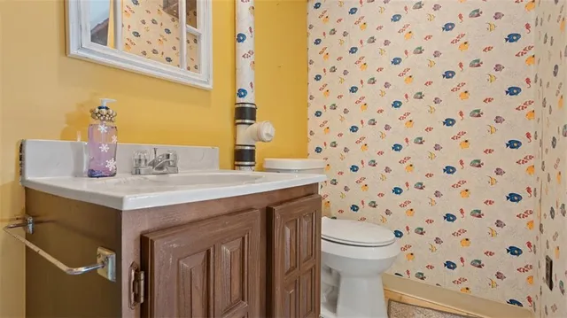 a bathroom with a sink toilet and a mirror