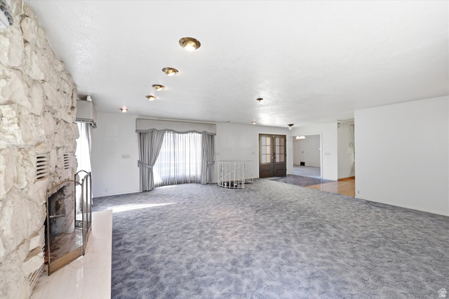 292 West 400 South Springville, UT 84663 - Photo 12 of 37 Spacious room featuring a prominent stone fireplace, recessed ceiling lighting, and a large window with sheer and opaque drapery