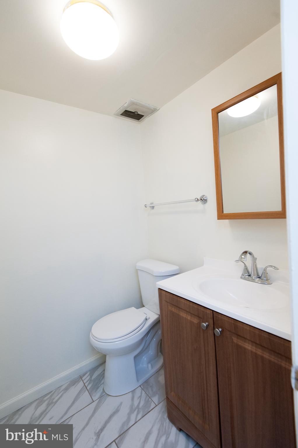 12013 Pheasant Run Drive Laurel, MD 20708 - Photo 15 of 34 a bathroom with a sink a toilet and mirror