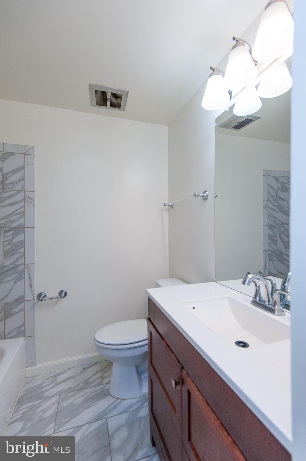 12013 Pheasant Run Drive Laurel, MD 20708 - Photo 30 of 34 a bathroom with a sink a toilet and a mirror