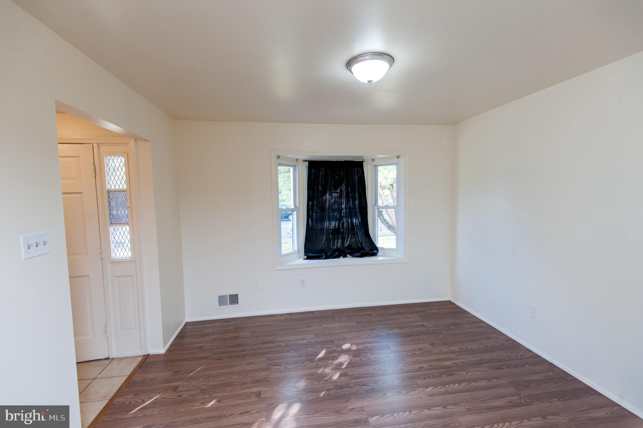 12013 Pheasant Run Drive Laurel, MD 20708 - Photo 7 of 34 a view of an empty room with wooden floor and a window