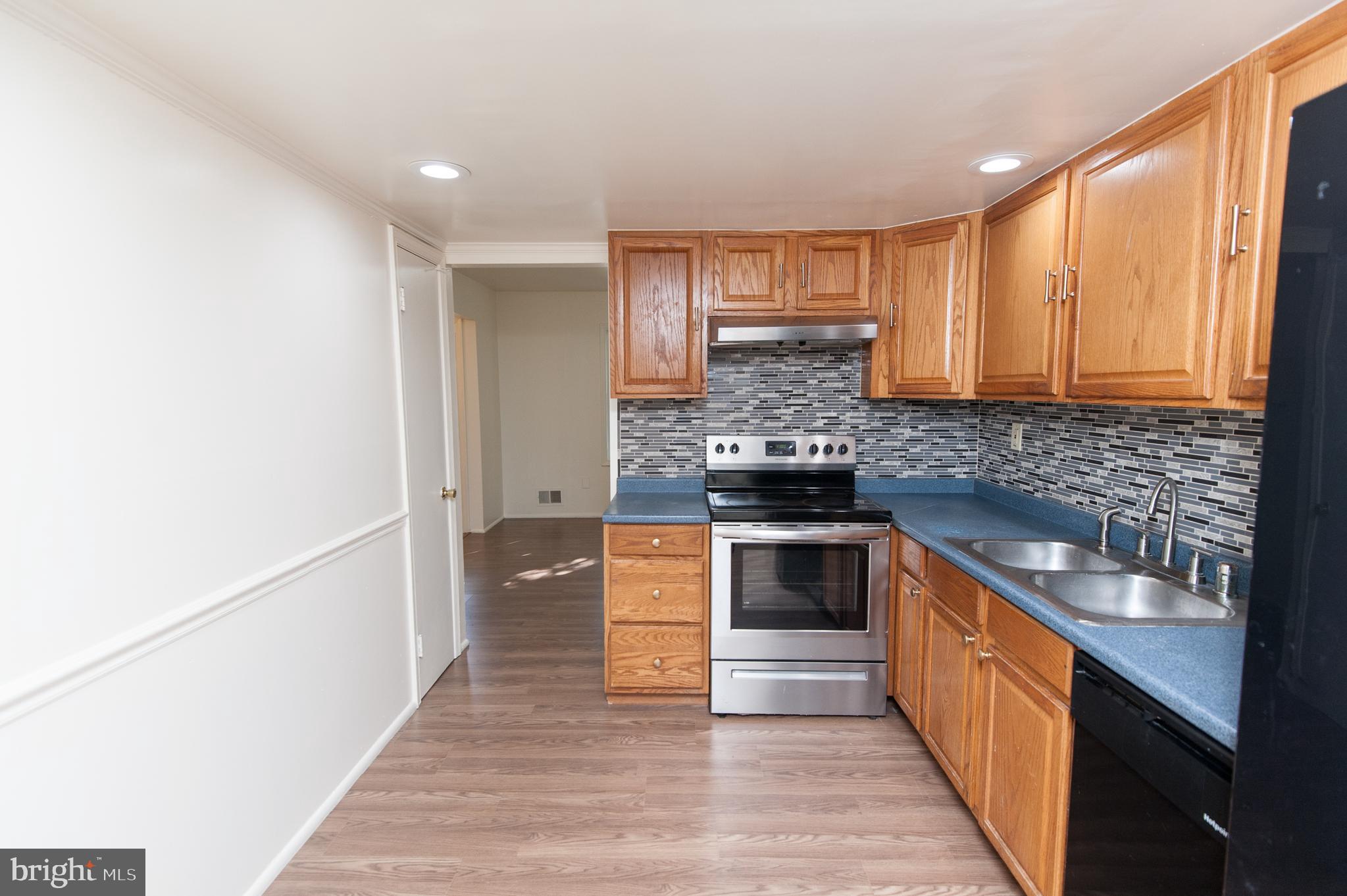 12013 Pheasant Run Drive Laurel, MD 20708 - Photo 9 of 34 a kitchen with stainless steel appliances granite countertop a stove a sink and a refrigerator