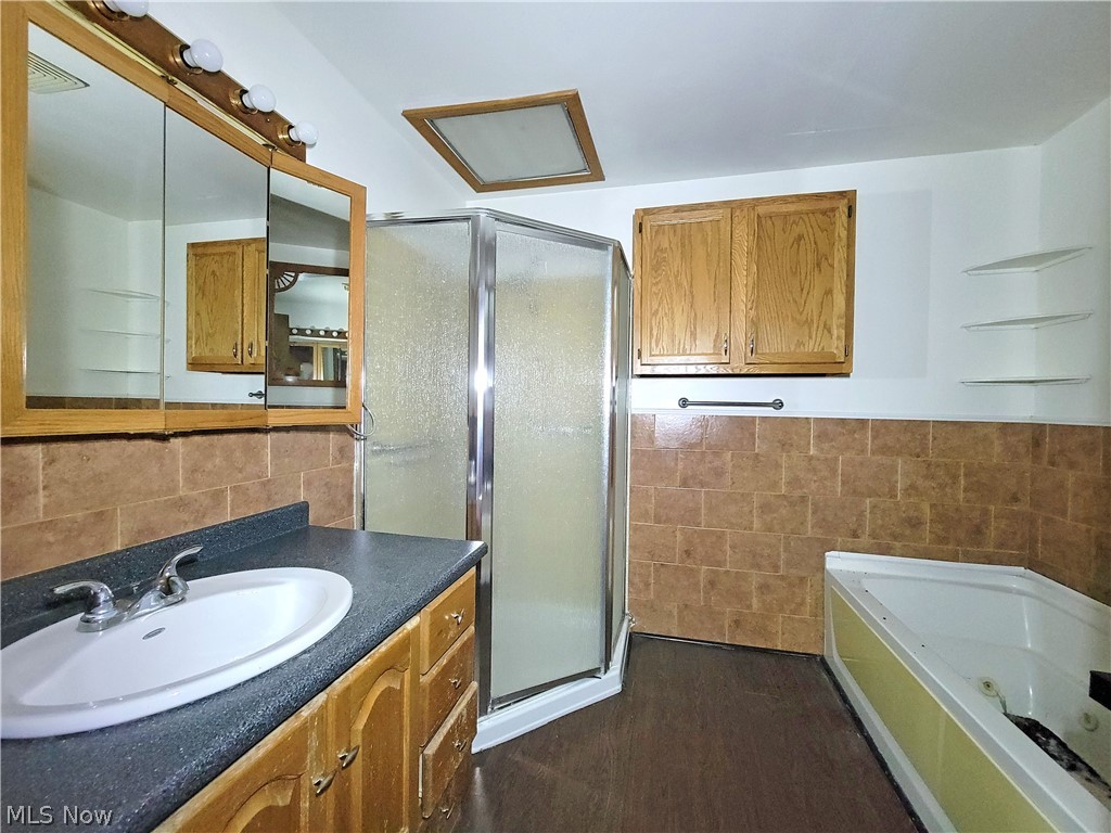 63 Old Ashby Ridge Road Parkersburg, WV 26104 - Photo 6 of 13 Bathroom featuring vanity, tile walls, hardwood / wood-style flooring, and separate shower and tub