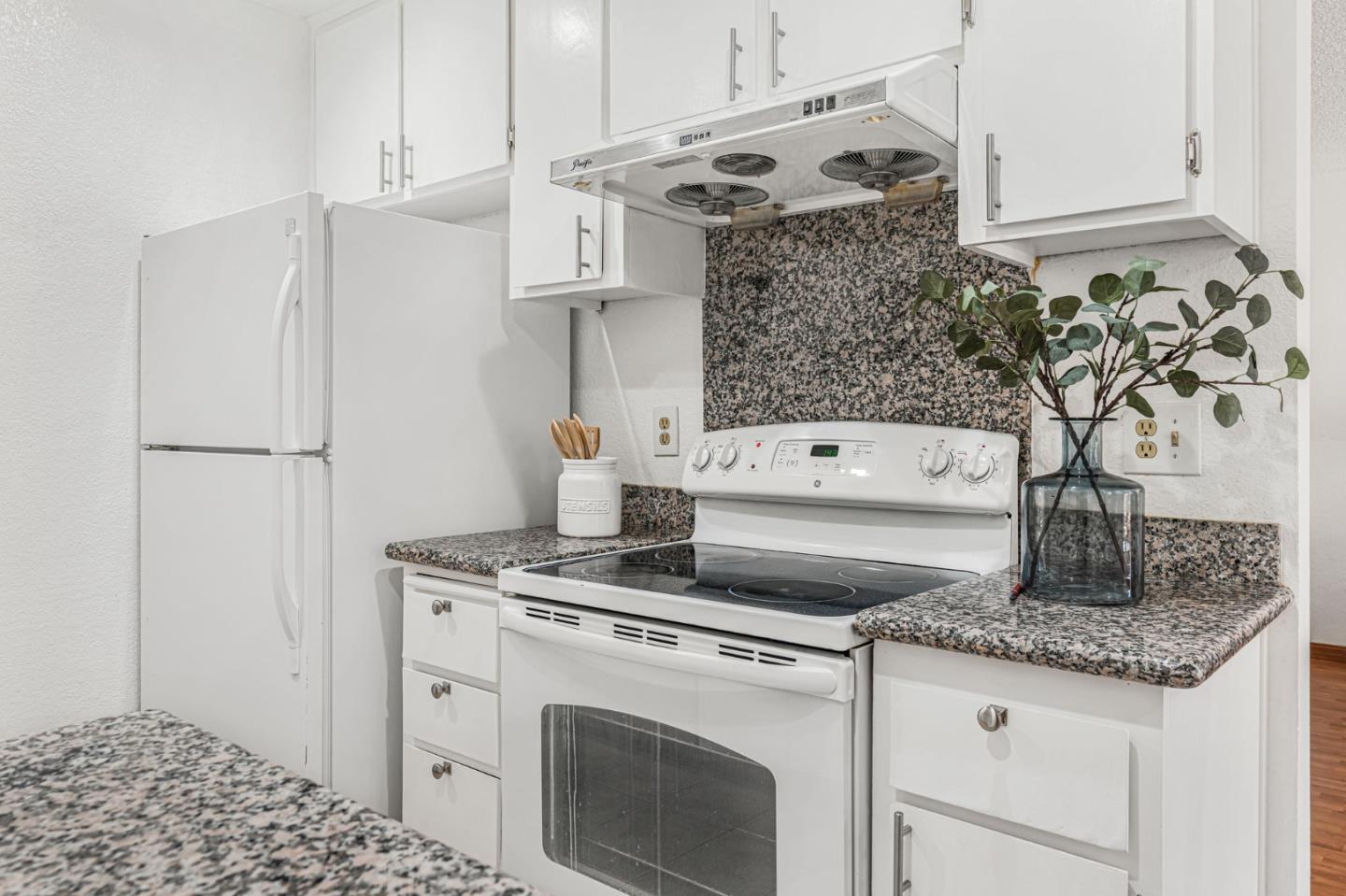 131 Wenatchee Common, Unit 14 Fremont, CA 94539 - Photo 8 of 30 a kitchen with granite countertop a white stove and cabinets