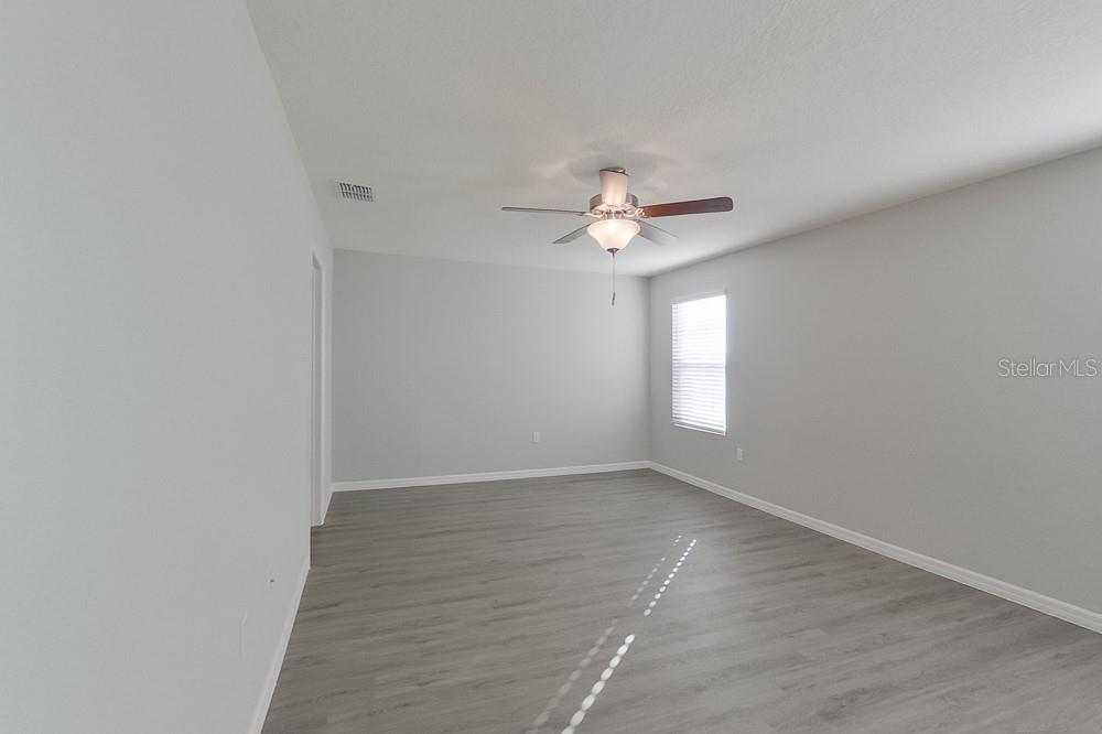 4397 Southwest 85th Lane Ocala, FL 34476 - Photo 17 of 23 an empty room with wooden floor and window