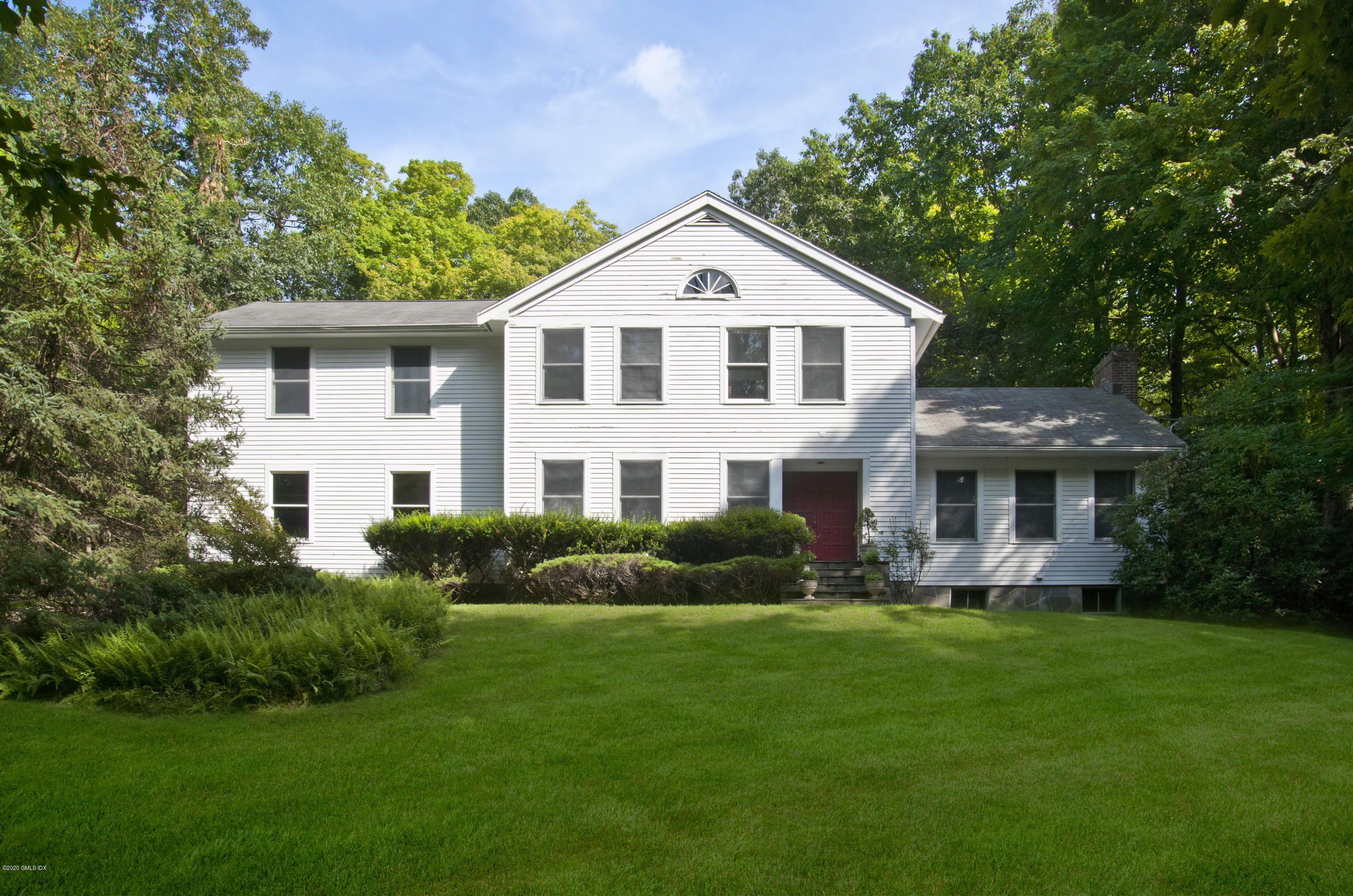 a front view of a house with a yard and trees