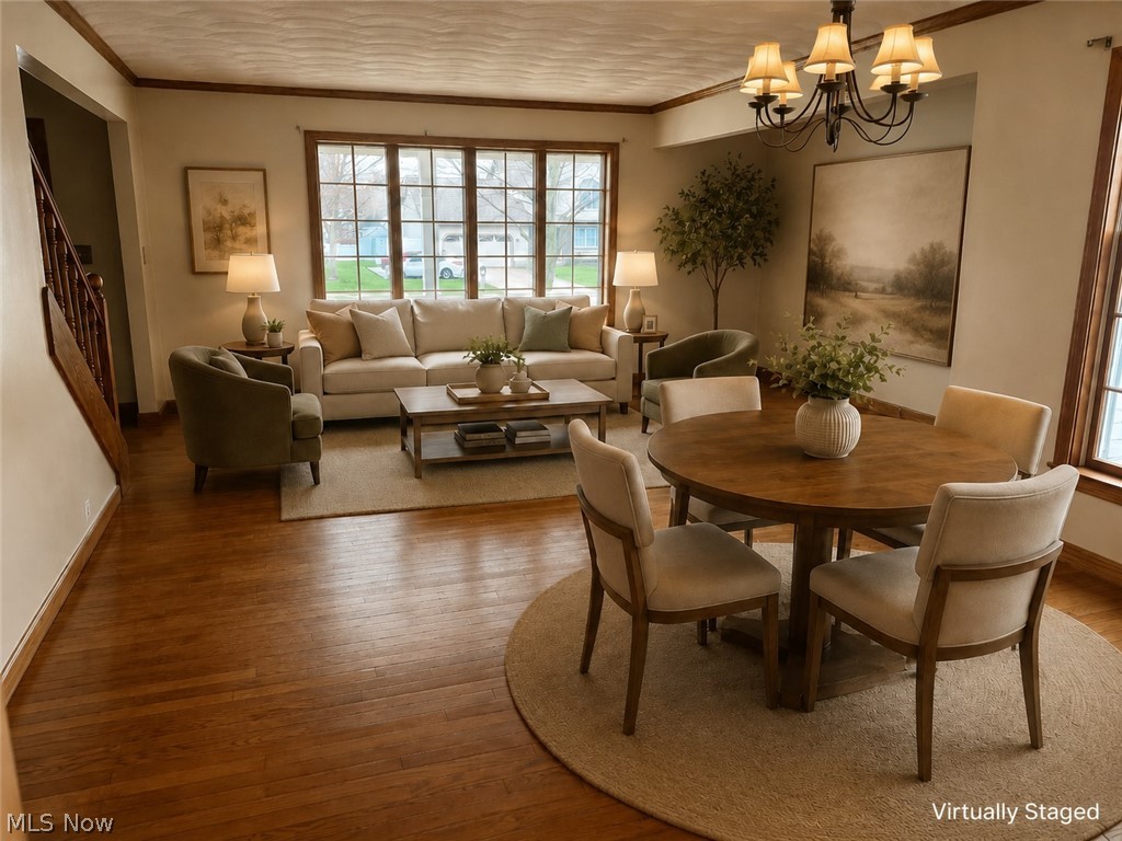 6416 Ridgeview Avenue Youngstown, OH 44515 - Photo 4 of 15 Open concept living space featuring wood-finish flooring, a large multi-pane window, and a chandelier with shaded lights