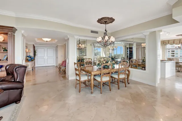 a bedroom with a bed a dresser and a chandelier