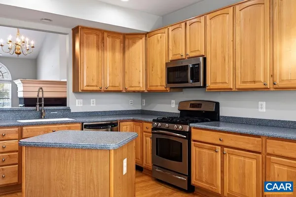 a kitchen with stainless steel appliances granite countertop a refrigerator a stove and a wooden floors