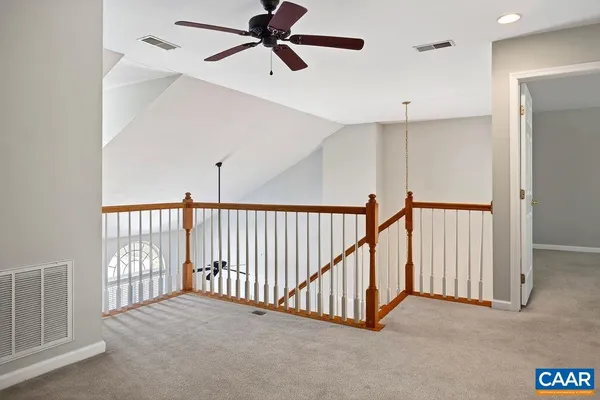 an empty room with a chandelier fan and closet