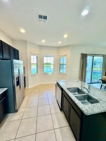 a kitchen with stainless steel appliances granite countertop a sink and a refrigerator